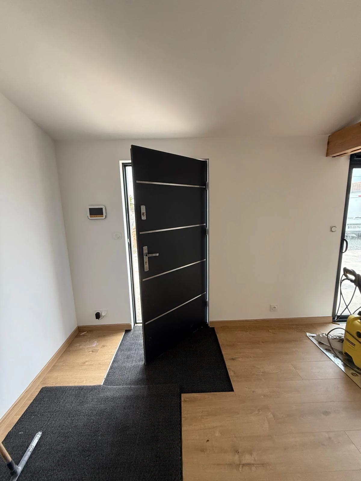 Porte d'entrée noire posée dans une pièce rénovée à La Bernerie-en-Retz