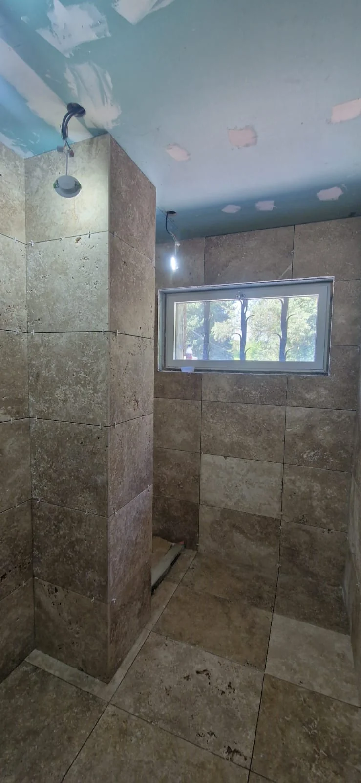 Douche à l'italienne carrelée en travertin à Fabrègues