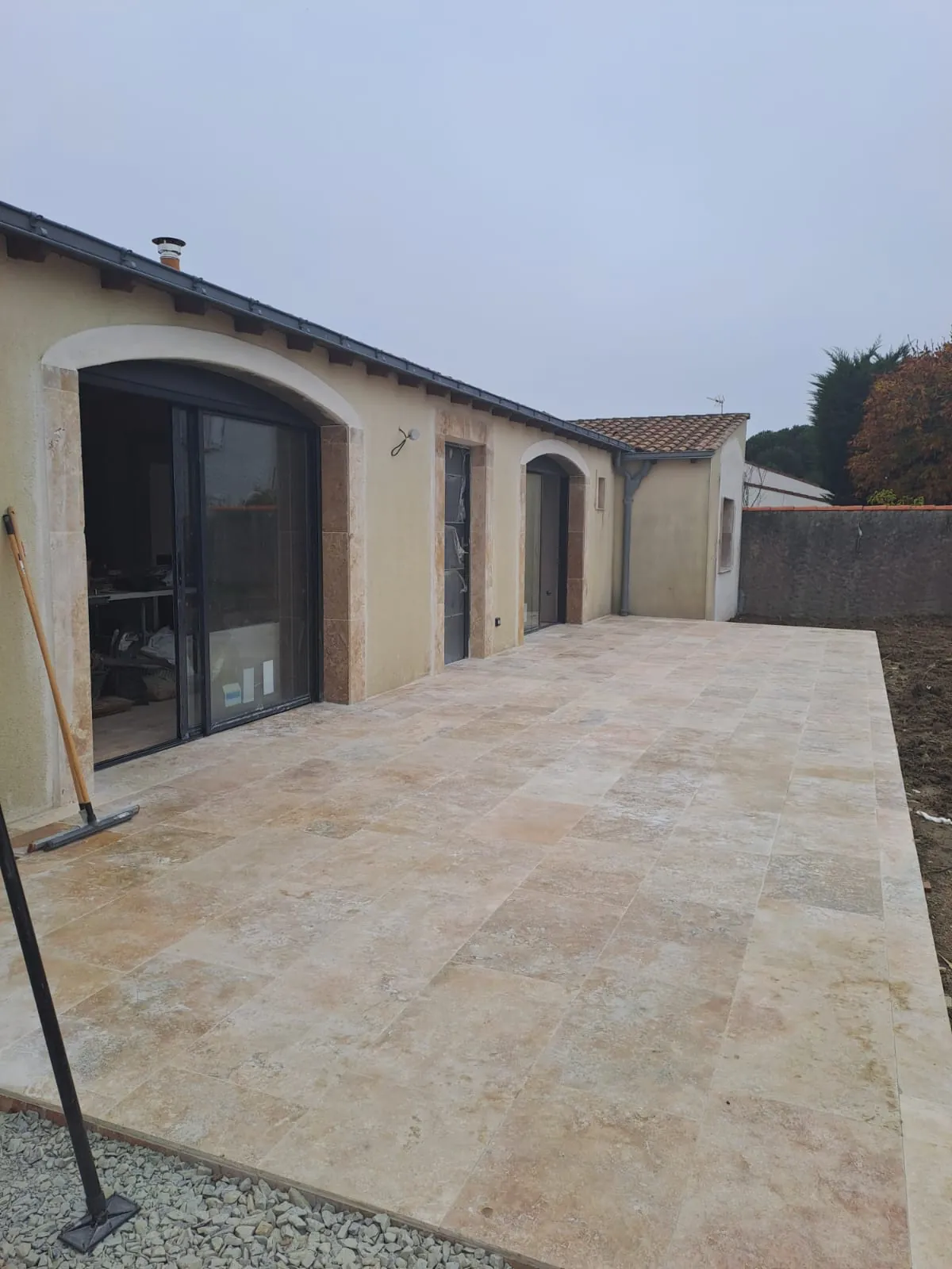 Terrasse en travertin devant une façade à arches à La Bernerie-en-Retz