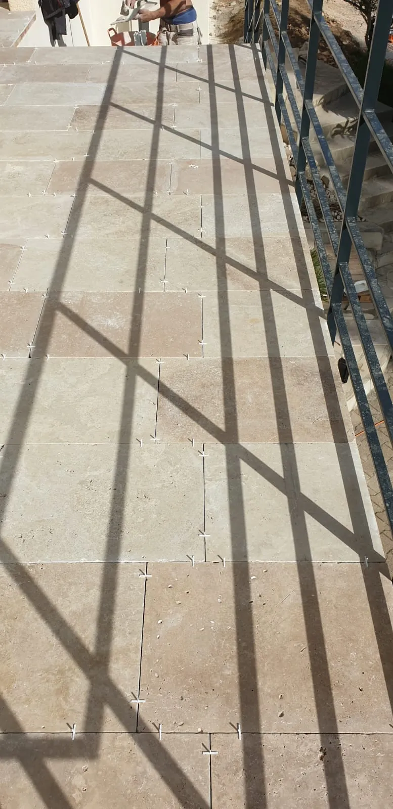 Dallage en travertin en cours de pose sur une terrasse à Saint-Gély-du-Fesc